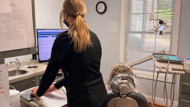A Roanoke Dental Center hygienist updating a patient's chart in the operatory
