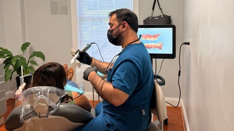 A Roanoke Dental Center dentist scanning a patient's teeth with a digital intraoral scanner