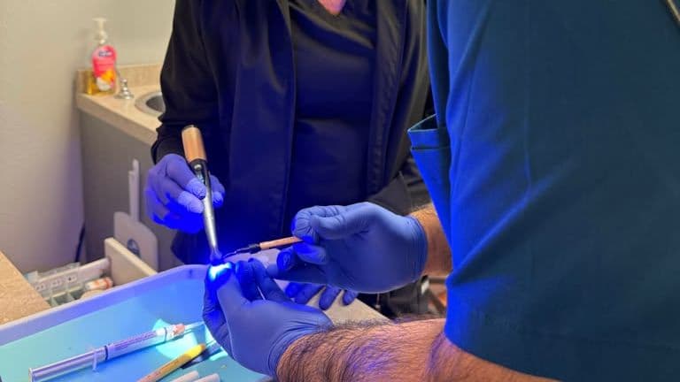 Roanoke Dental Center team members preparing restorative materials with a curing light